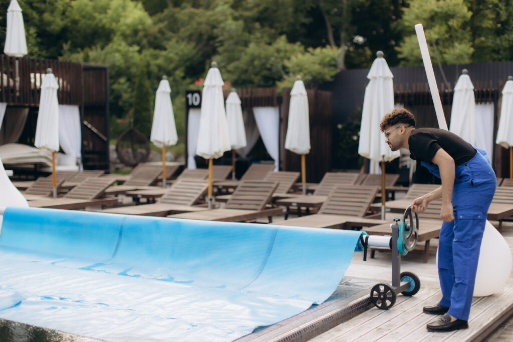 A professional performing pool opening service for a swimming pool